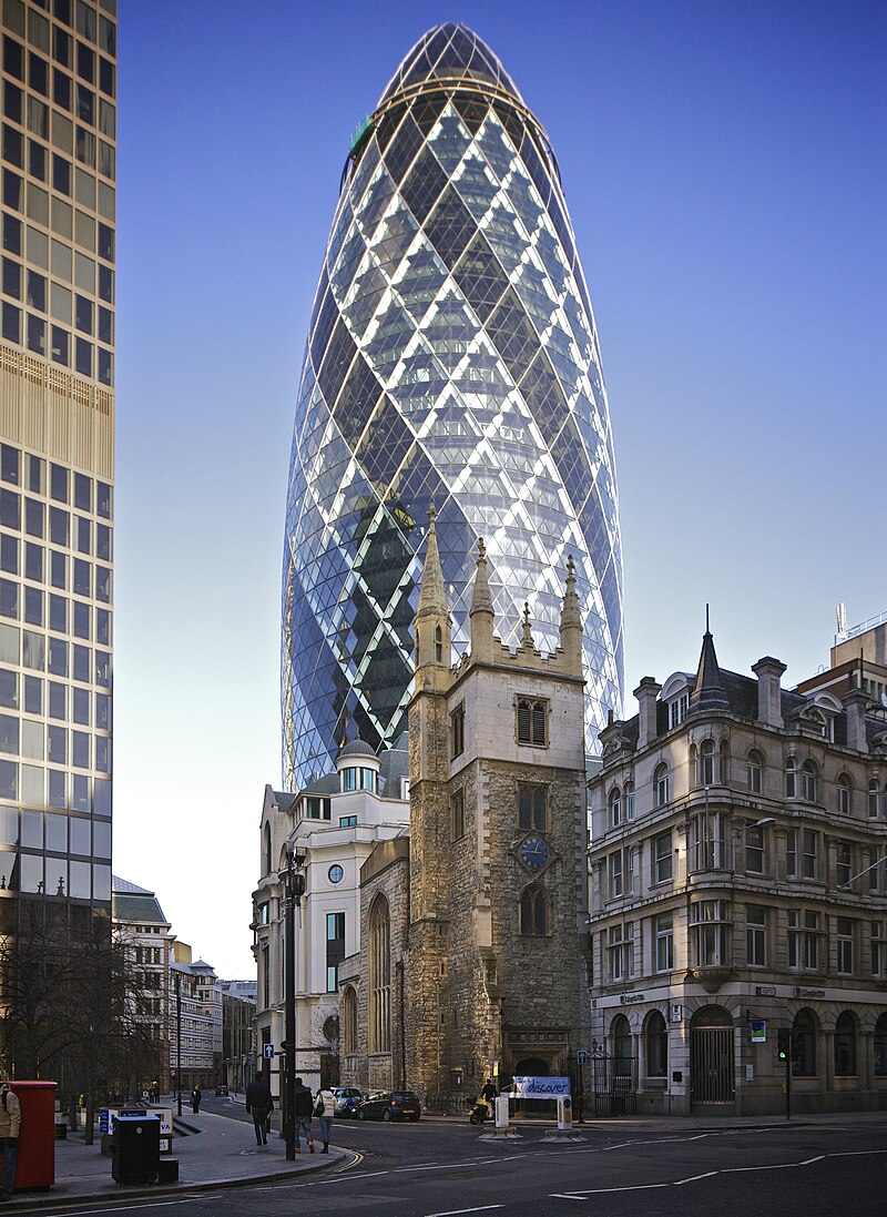 photo of buildings in City of London, ancient church in foreground, metal and glass cucumber-shaped building looming behind it